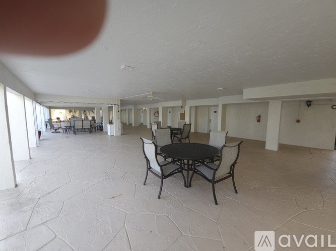 A spacious room with a table and chairs.