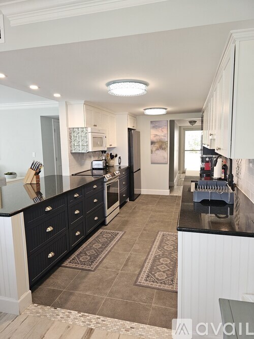 A kitchen with black cabinets and a tiled floor.