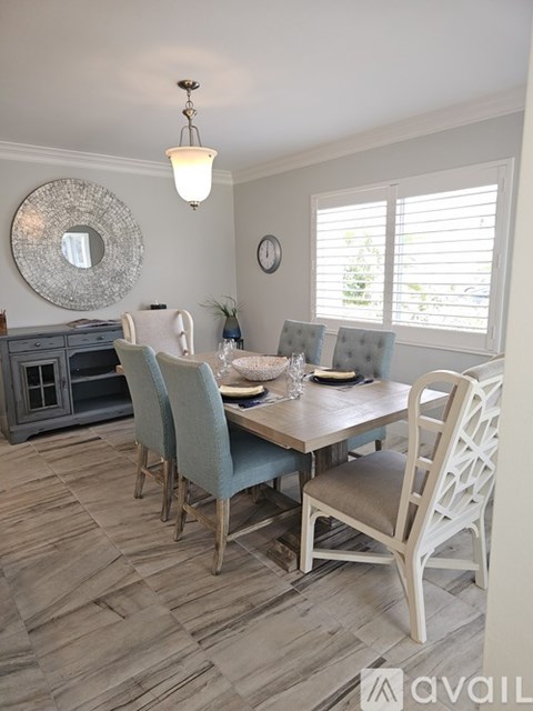 A dining room with a wooden table and chairs.