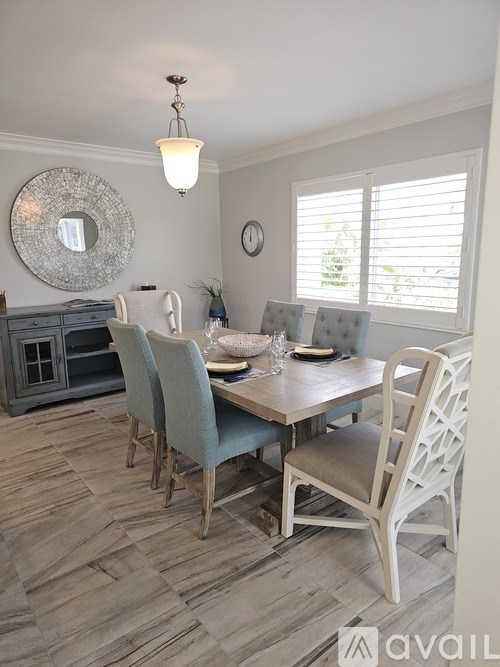 A dining room with a wooden table and chairs.
