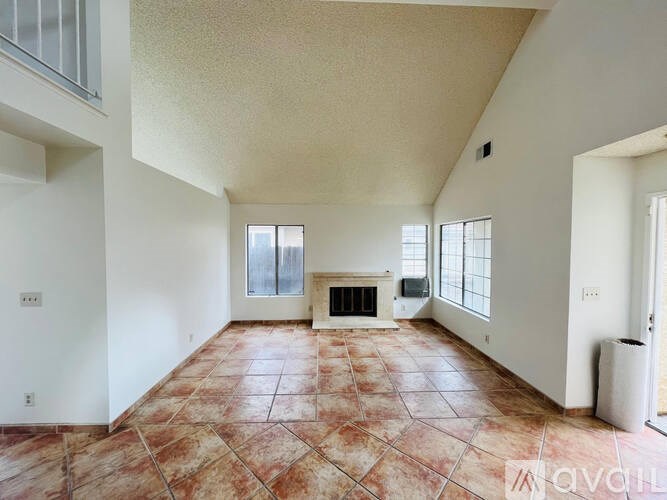 A living room with a fireplace and tile flooring.