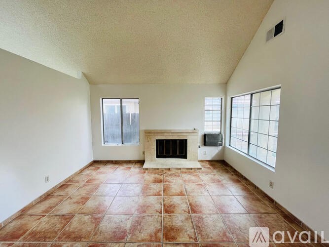 A room with a fireplace and tiled flooring is available for rent.