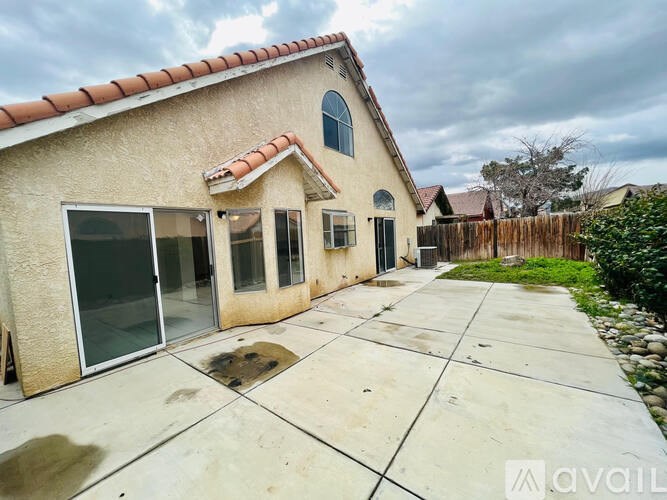 A house with a beige exterior and a red tile roof is for sale.