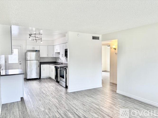 A spacious kitchen with white cabinets and a grey floor.
