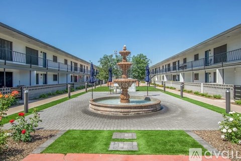 A fountain in the middle of a courtyard surrounded by buildings.