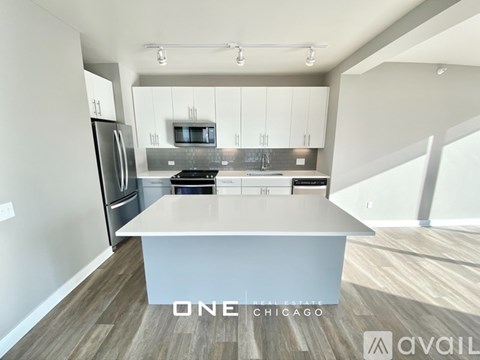 A modern kitchen with a refrigerator, stove, and microwave.