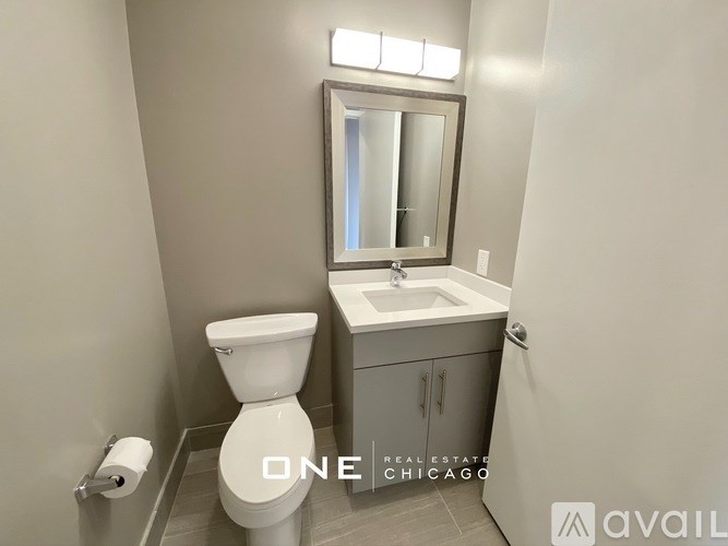 A bathroom with a toilet, sink, and mirror.