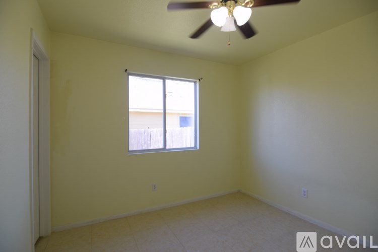 A room with a ceiling fan and a window.