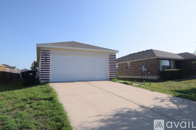 A house with a garage and a driveway in front of it.