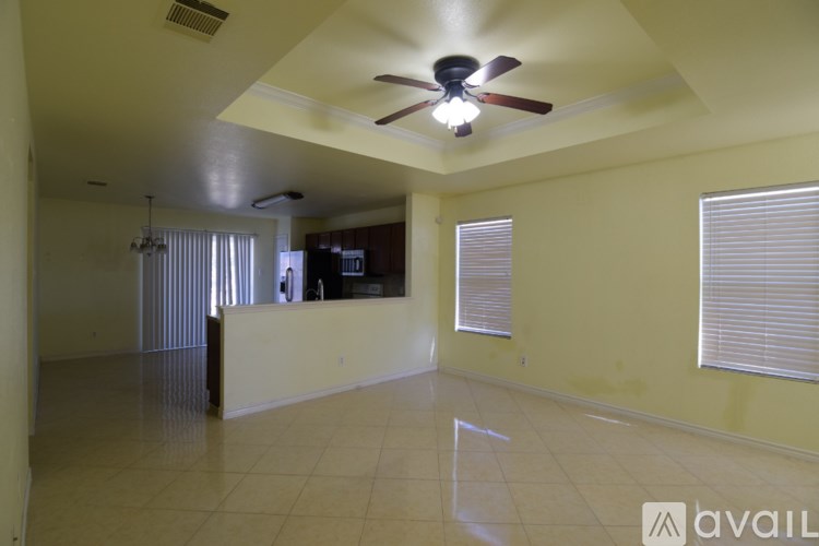 A spacious room with a ceiling fan and tiled flooring.