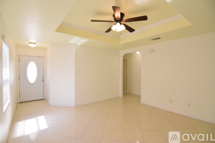 A room with a ceiling fan and a window with blinds.
