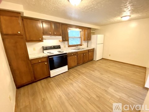 A kitchen with wooden cabinets and a white refrigerator.