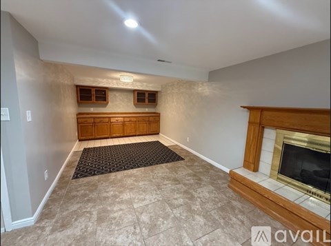A living room with a fireplace and a rug on the floor.
