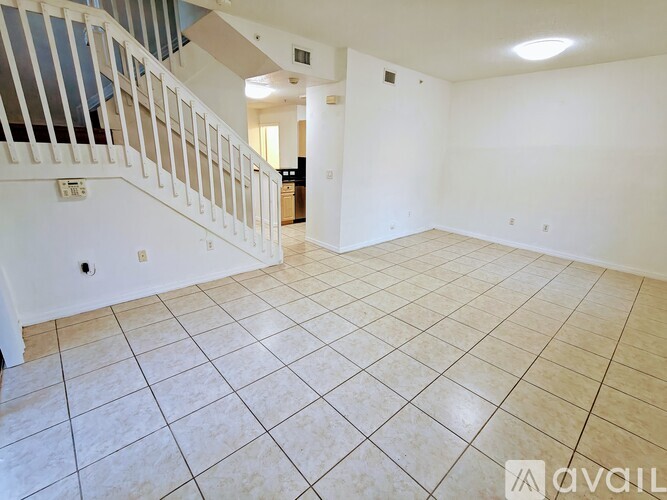 A spacious room with a staircase and tiled flooring.