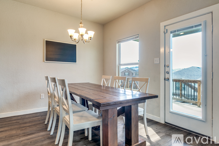 A dining room with a wooden table and chairs.