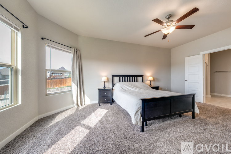 A bedroom with a large bed and a ceiling fan.