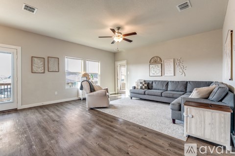 A living room with a grey couch and a wooden cabinet.