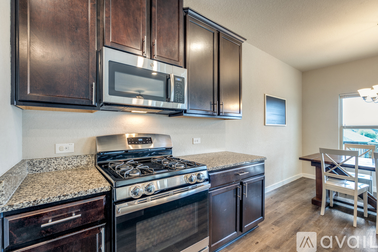 A kitchen with dark wood cabinets and a granite countertop.