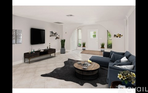 A living room with a black cowhide rug and a grey sofa.