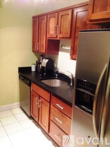 A kitchen with wooden cabinets and a black counter top.