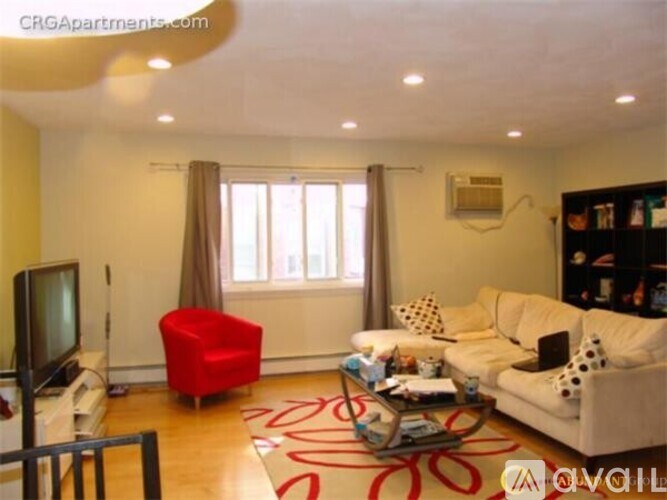 A living room with a red chair and a white couch.