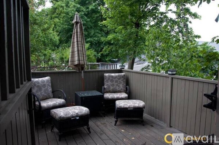 A patio with a table, chairs and an umbrella.