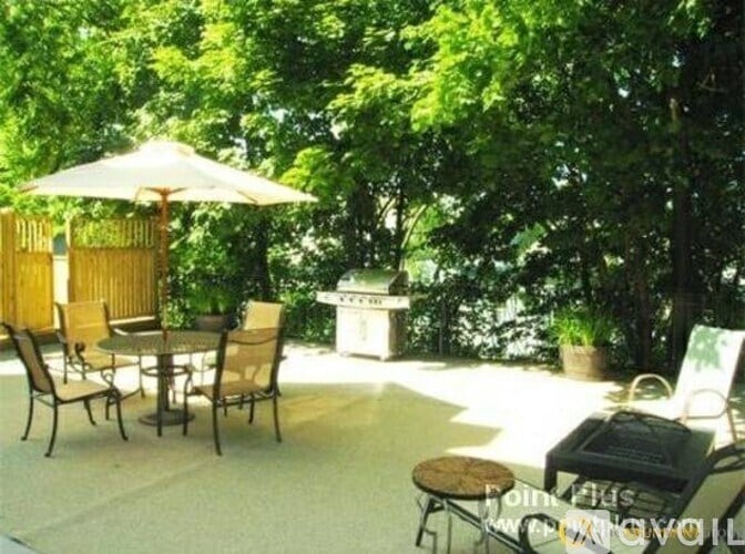 A patio with a table and chairs and an umbrella.