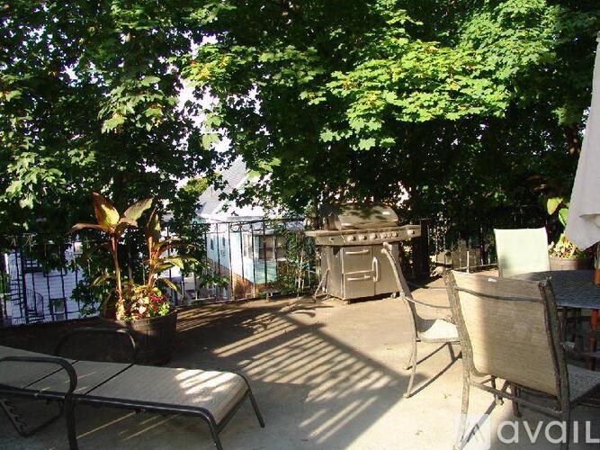 A patio with a table and chairs is surrounded by trees.