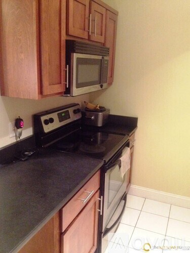 A black stove top oven with a silver pot on it.