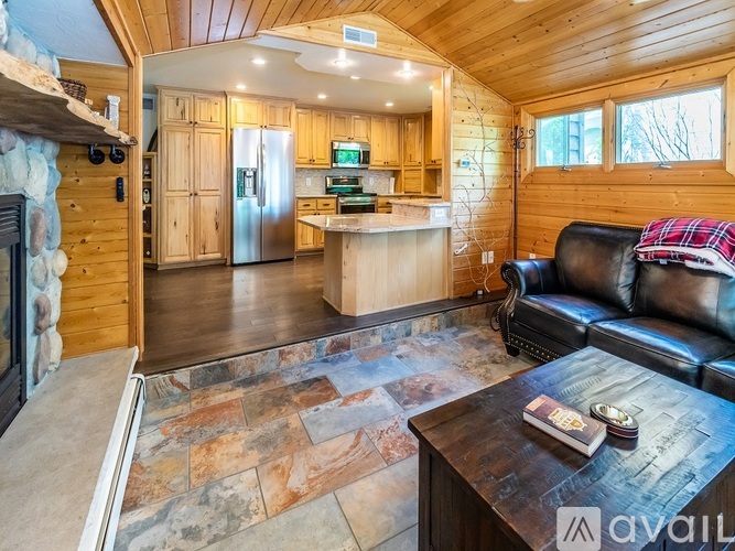 A living room with brown leather furniture and a wooden coffee table.