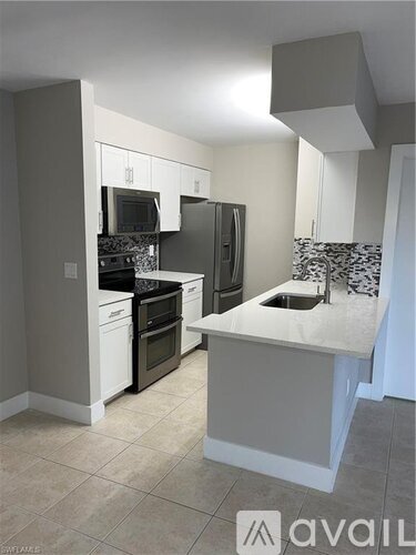 A kitchen with white cabinets and a tiled backsplash.