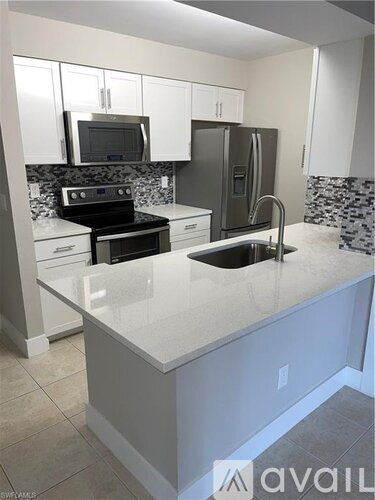 A kitchen with a sink, stove, and refrigerator.