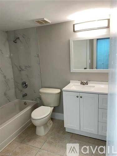 A bathroom with a toilet, sink, and bathtub.