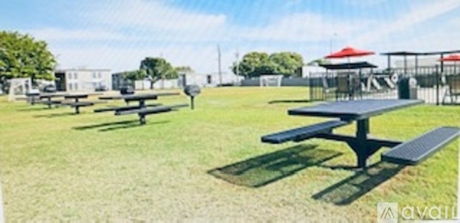 A park with picnic tables and umbrellas.