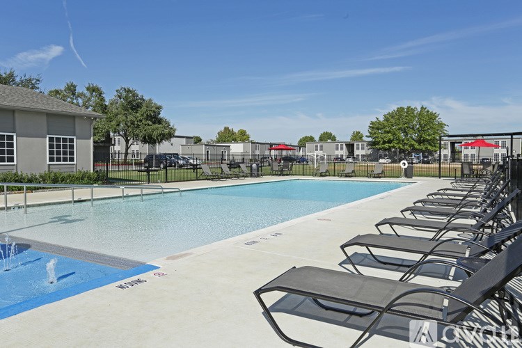 A pool with a fountain in the middle and lounge chairs around it.