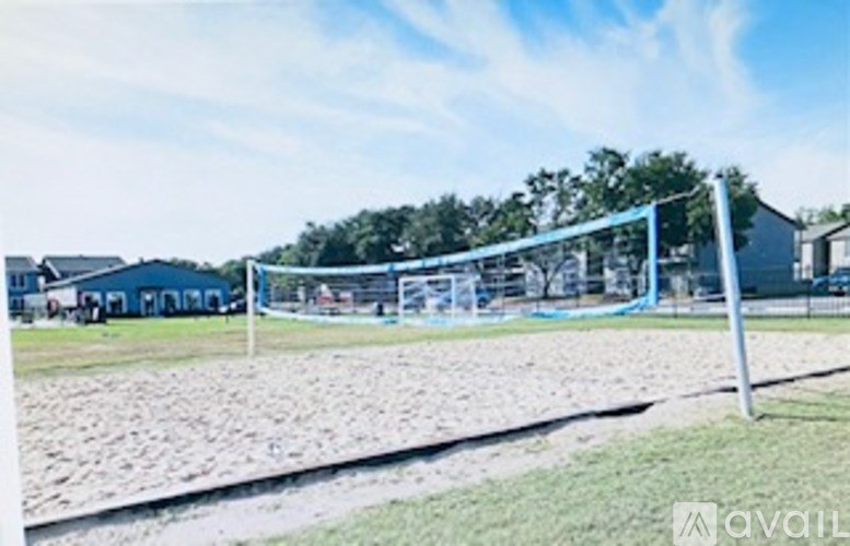 A soccer goal stands on a field with a blue sky in the background.