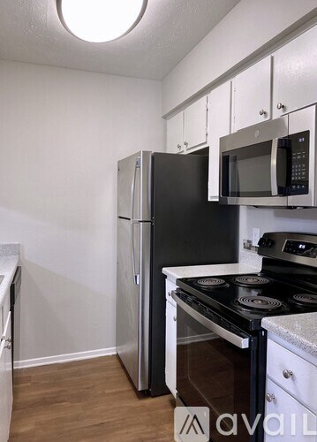 A kitchen with a black refrigerator, stove, and microwave.