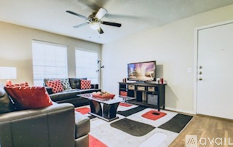 A living room with a black couch and a television.