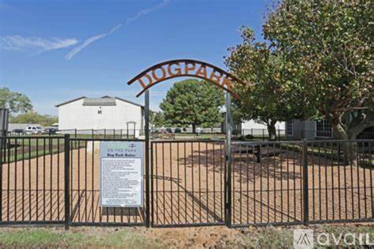 A sign that says Doigh Park is in front of a fence.