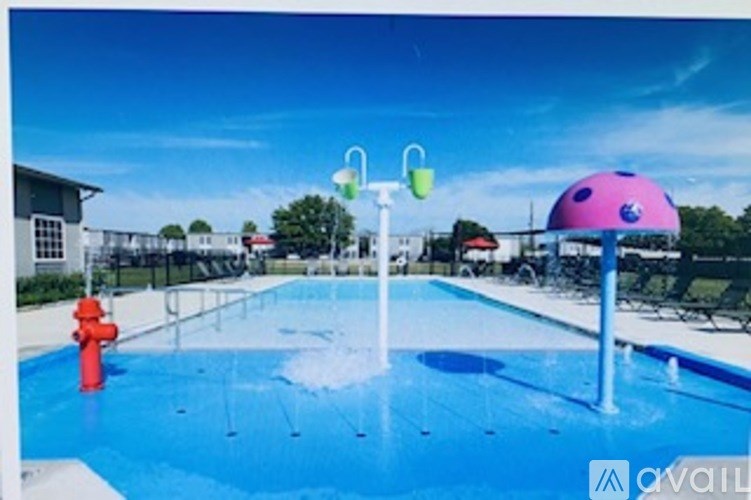 A pool with a red fire hydrant and a purple umbrella.