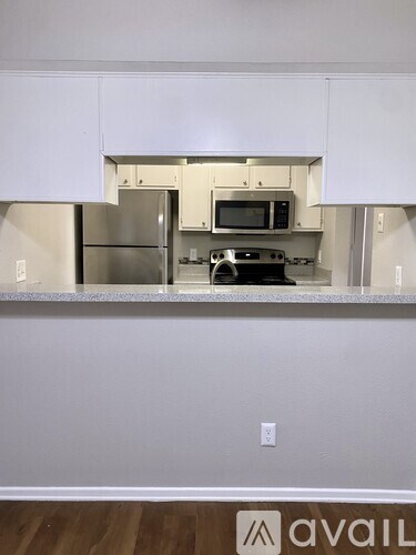 A kitchen with a stainless steel refrigerator and microwave built into the cabinetry.