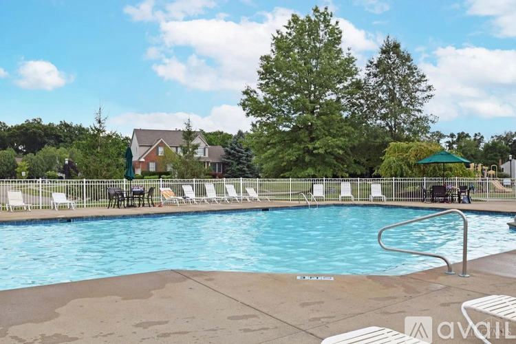 A swimming pool surrounded by lounge chairs and trees.