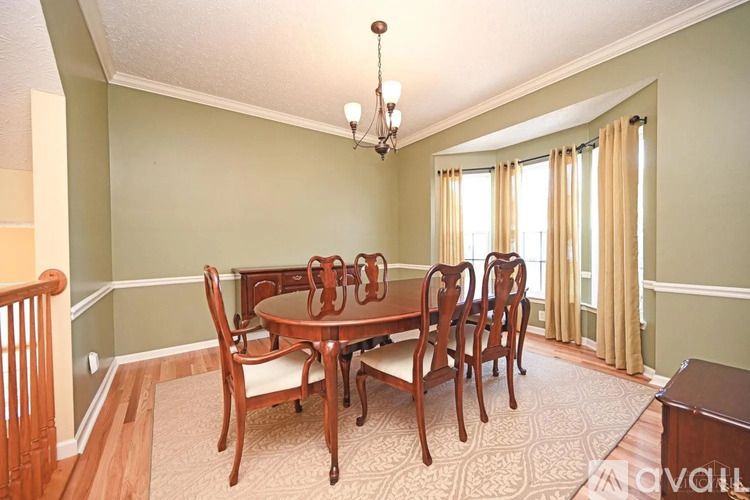 A dining room with a wooden table and chairs.