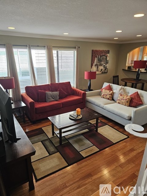 A living room with a red couch and a coffee table.