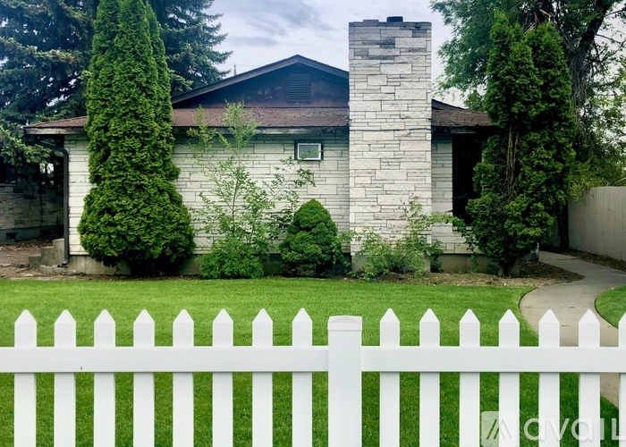 A white picket fence in front of a house.