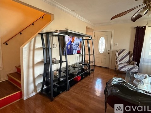 A living room with a television and a staircase.