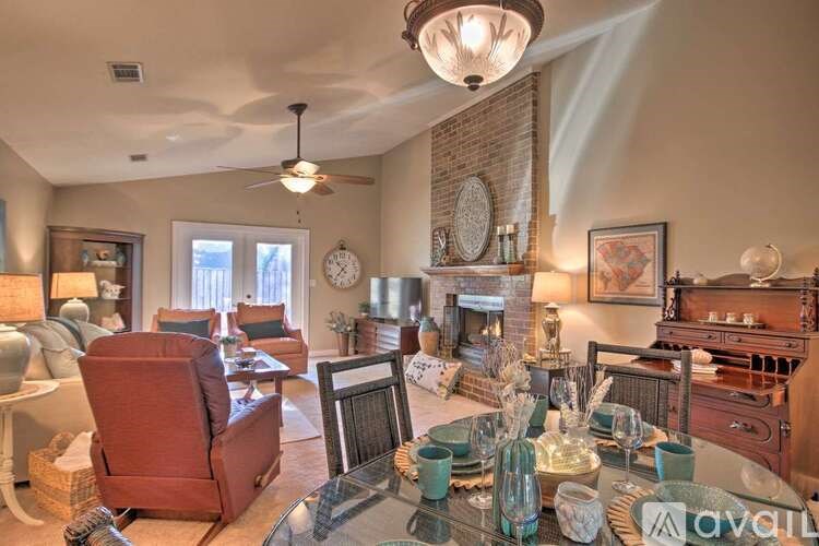 A living room with a glass table and a red chair.