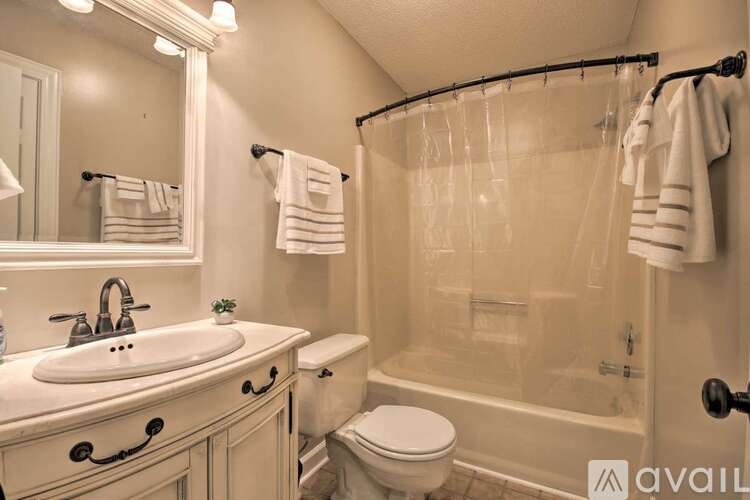 A bathroom with a white sink, toilet, and bathtub.