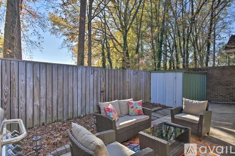 A backyard with a wooden fence and patio furniture.