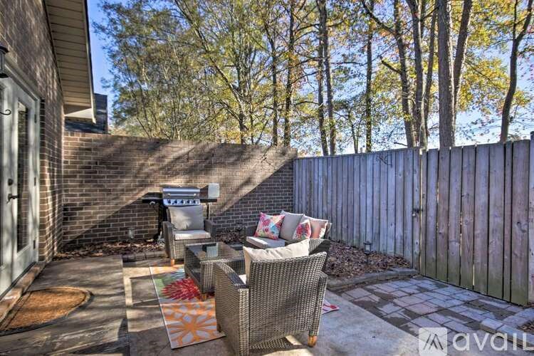 A patio with a chair and a table with a sign that says "For Sale".